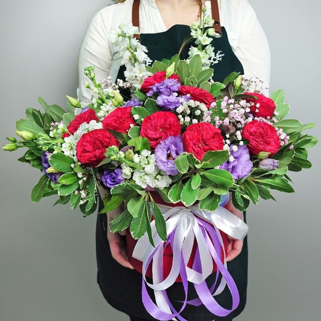 Композиция из Ред Пиано, Маттиолы, Дельфиниума и Эустомы в шляпной коробке «Жаклин»