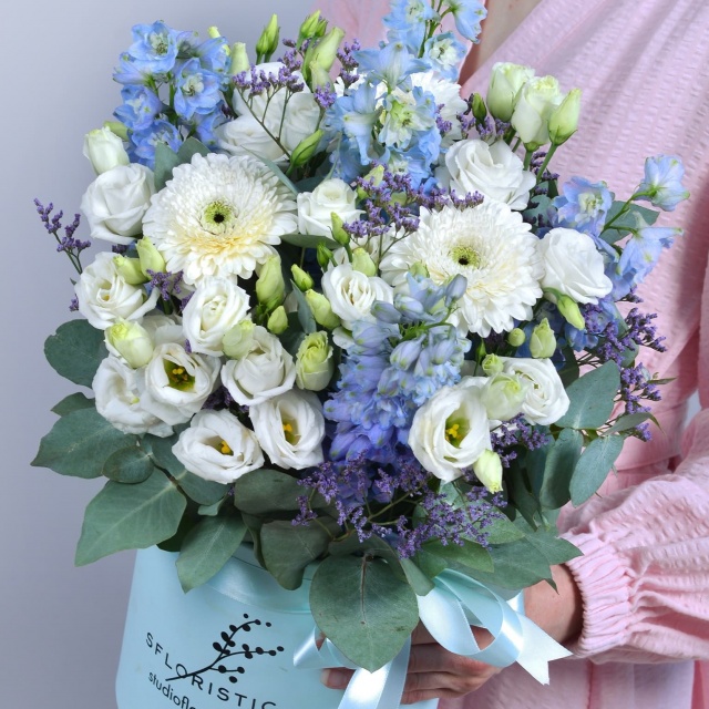 Композиция из Эустомы, Дельфиниума в шляпной коробке «Нежность неба»