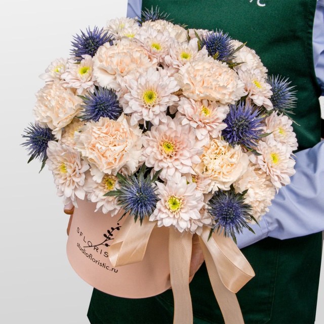 Композиция из Гвоздик, Хризантем и Эрингиума в шляпной коробке «Сахарный иней»